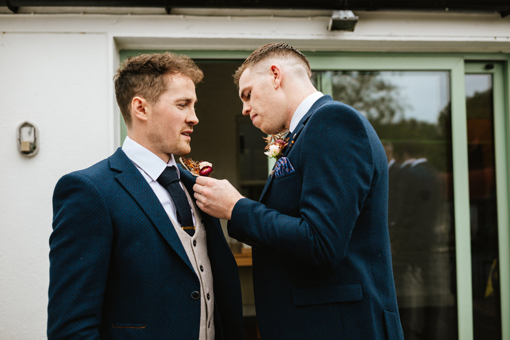 Groom groomsmen fixing tie suit