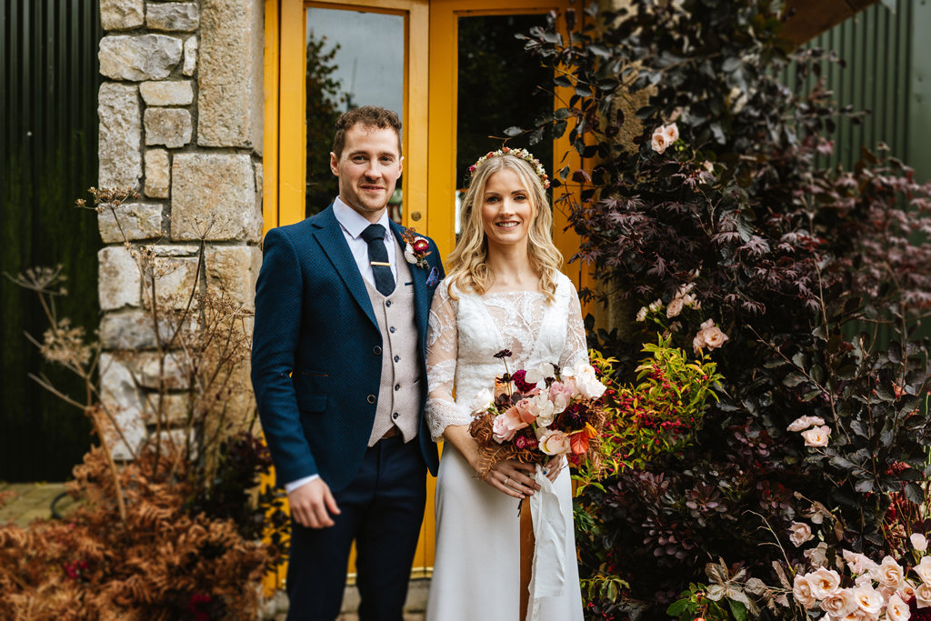 Bride groom lace dress detail embrace flowers bouquet exterior venue