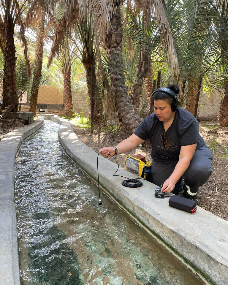 Diana Chester, in all black, dangles a microphone over the water channel.