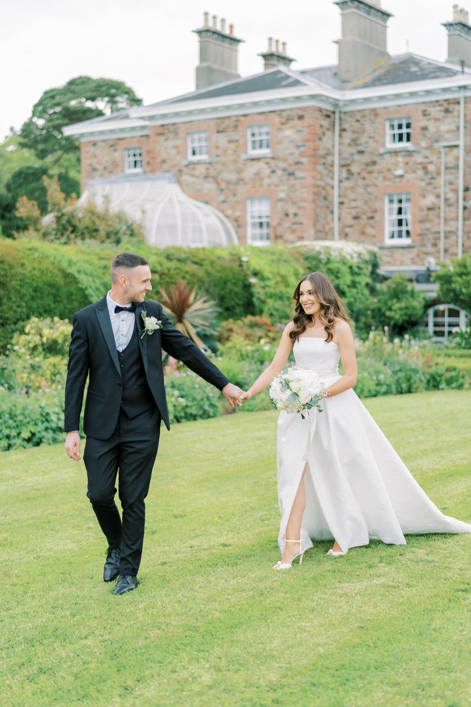 Bride groom white flower bouquet exterior garden holding hands
