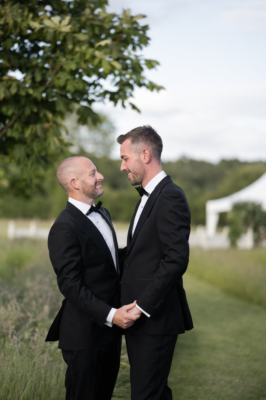 Grooms hand in hand holding hands in garden