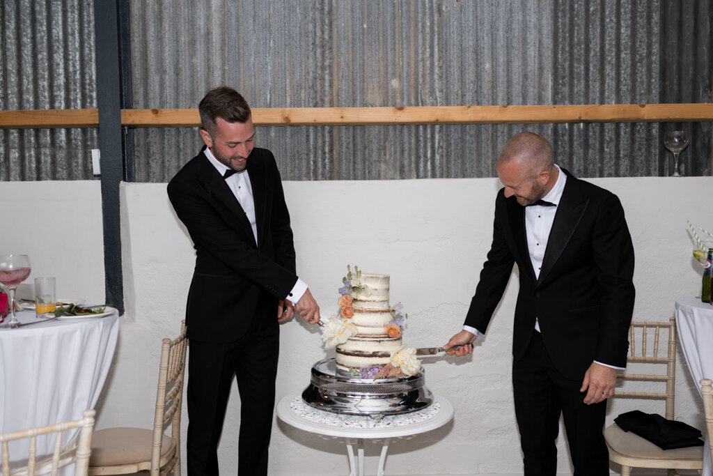 Groom and groom cutting cake