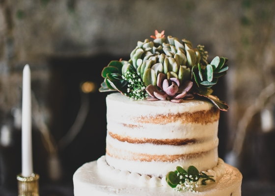 A wedding cake decorated with succulents. 