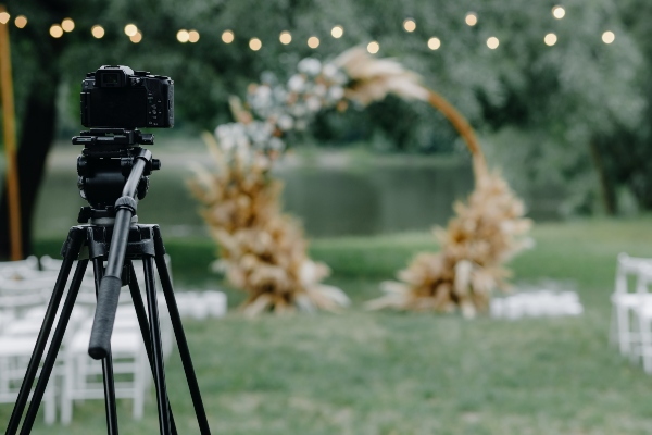 A wedding ceremony arch with a camera set up in front of it.