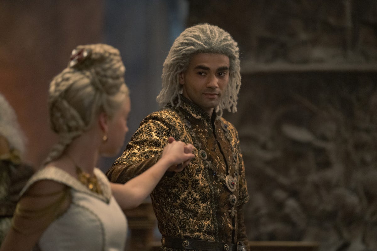 Laenor and Rhaenyra hold hands in a formal dance