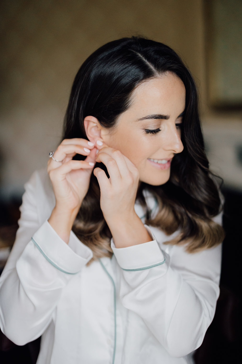 bride putting on earrings