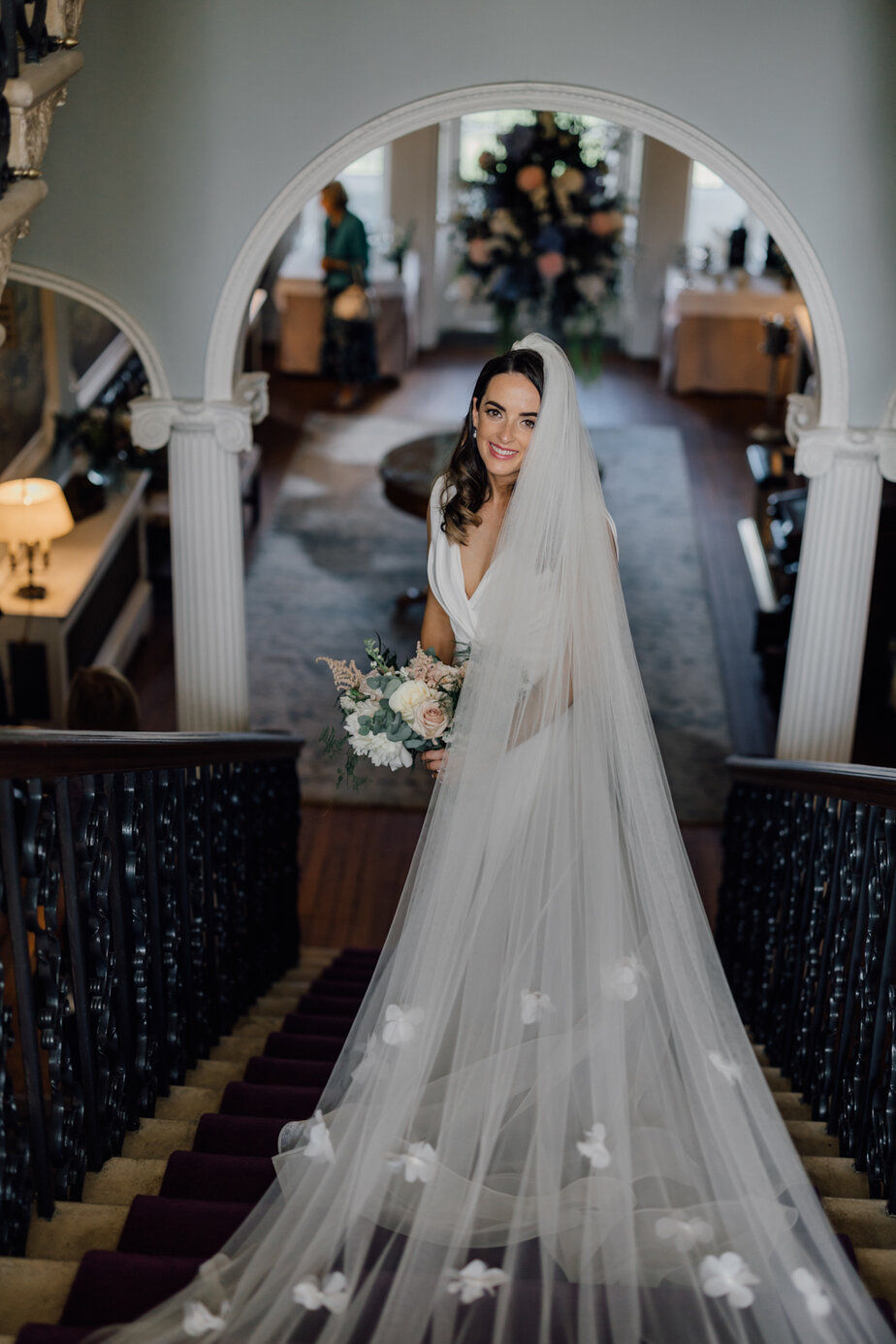 bride in dress veil and holding bouquet 