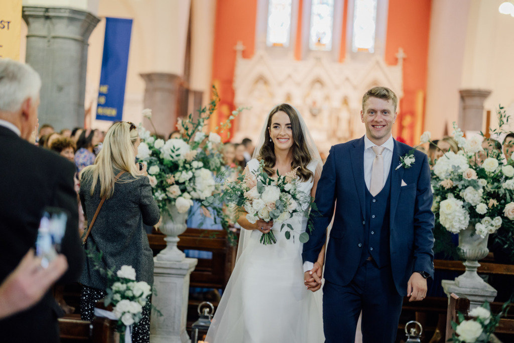 bride and groom walking down aisle flowers 