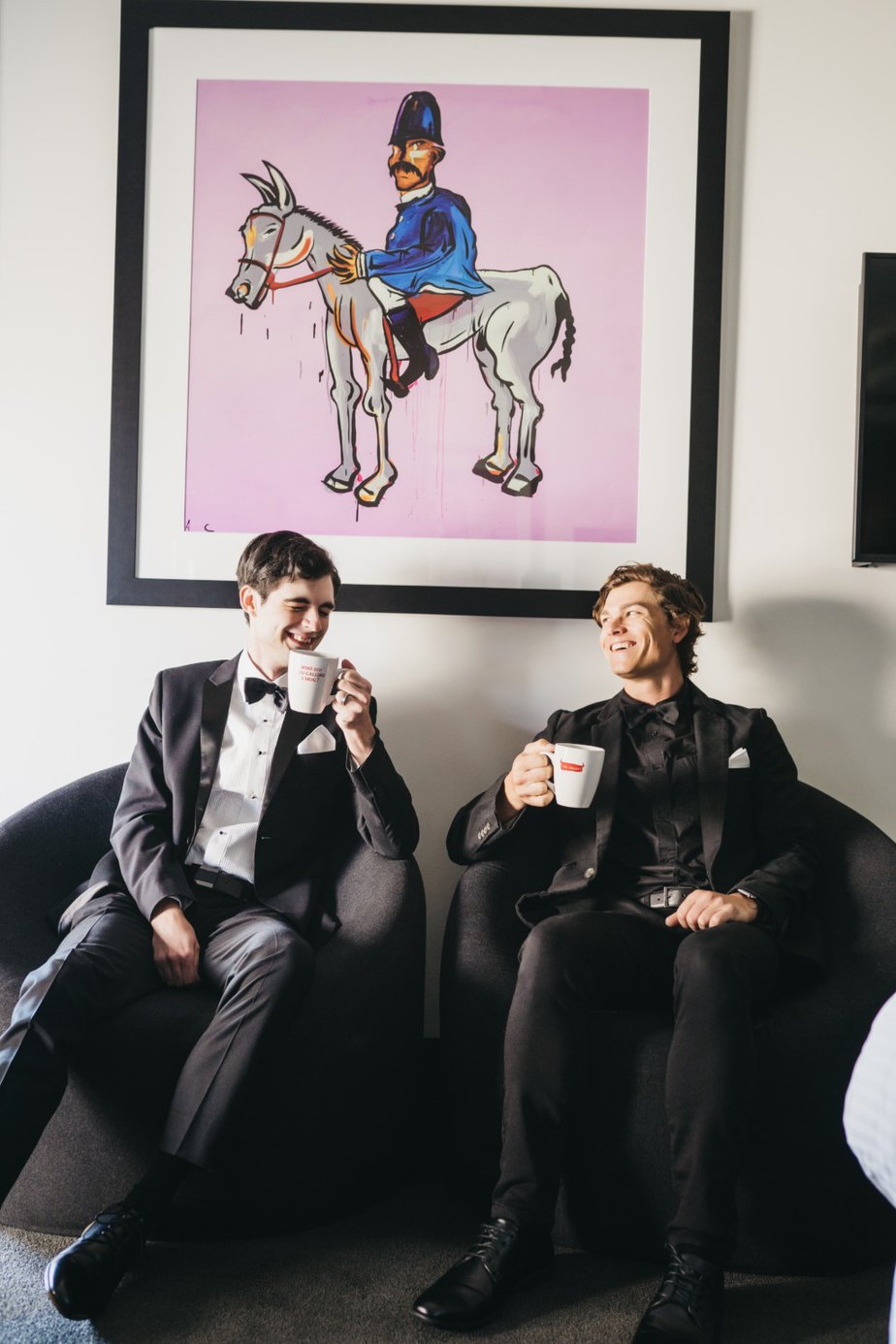 Groom and groomsman or best man sitting down with coffee