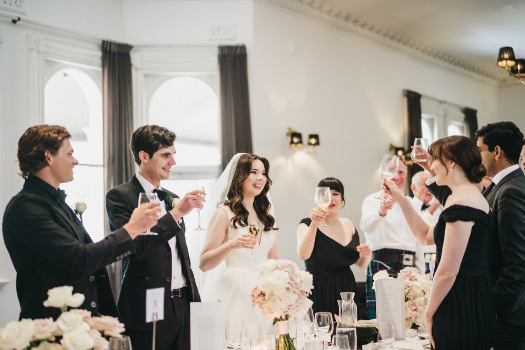 Bride grooms cheers guests table champagne