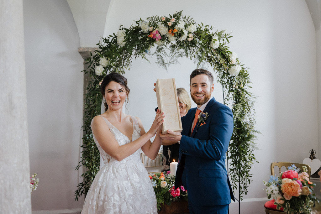 Bride and groom in front of guests smiling laughing