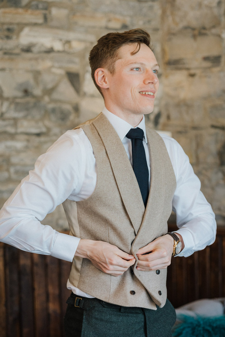 Groom putting on suit