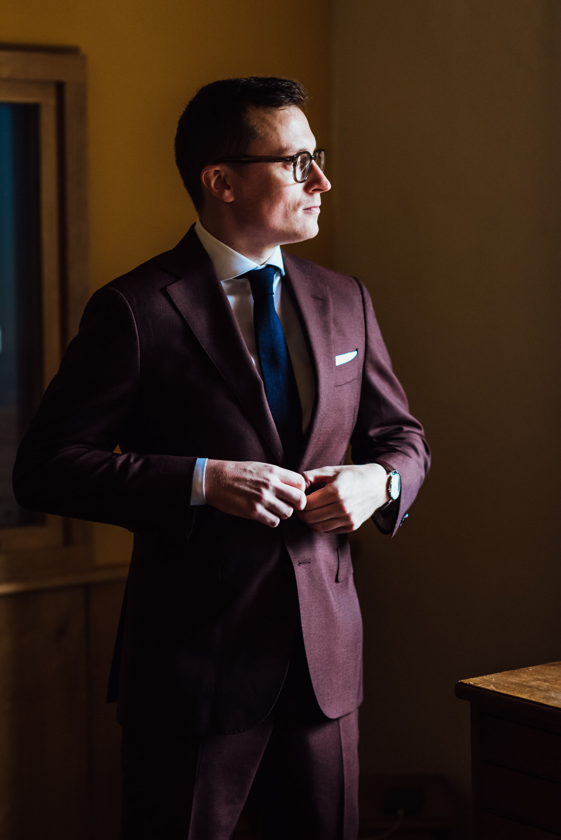 Groom in burgundy suit from Suit Supply.