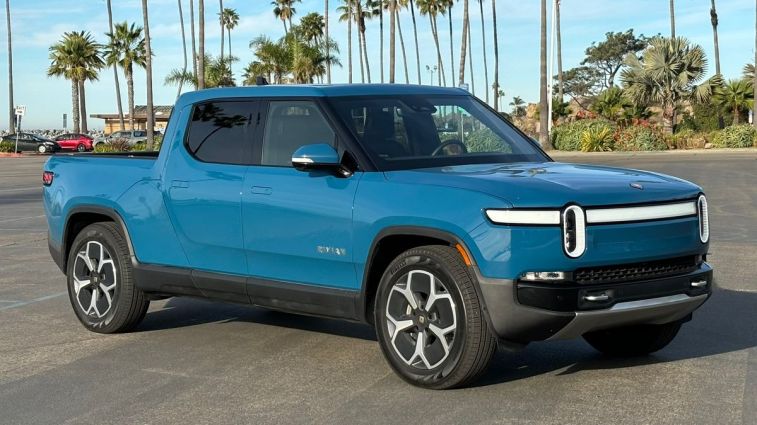 2024 Rivian R1T in blue in a parking lot.