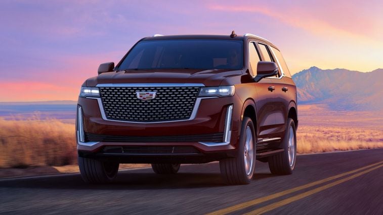 2024 Cadillac Escalade Premium Luxury in Mahogany Metallic driving on a highway.