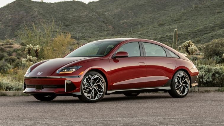 2024 Hyundai IONIQ6 Limited in red with hills and cactus in the background.