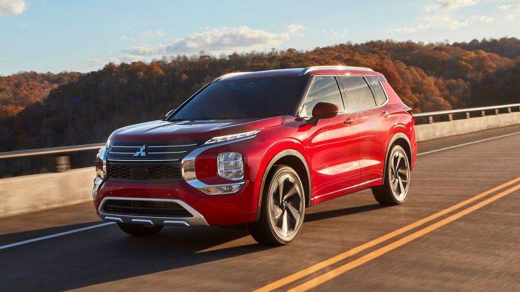 2024 Mitsubishi Outlander in red driving on a bridge.