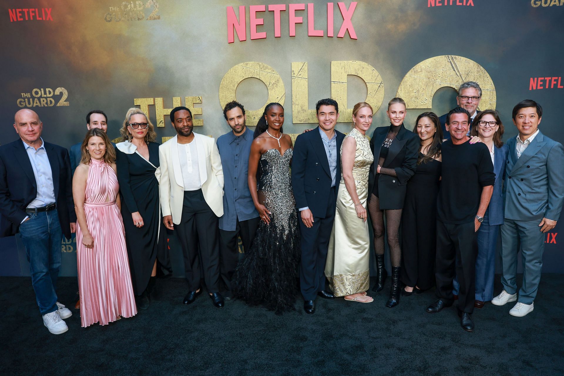 (L-R) Don Granger, Ruth Barrett, Steffen Thum, Victoria Mahoney, Chiwetel Ejiofor, Marwan Kenzari, KiKi Layne, Henry Golding, Uma Thurman, Charlize Theron, Beth Kono, A.J. Dix, Marc Evans, Dana Goldberg and Dan Lin attend Netflix's premiere of The Old Guard 2 at Netflix Tudum Theater on June 25, 2025 in Los Angeles, California. (Image via Getty)