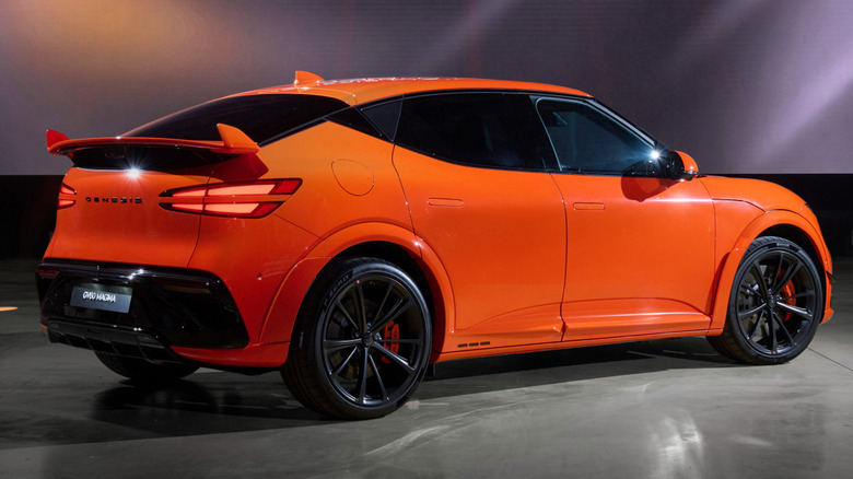 Rear 3/4 view of an orange Genesis GV60 Magma