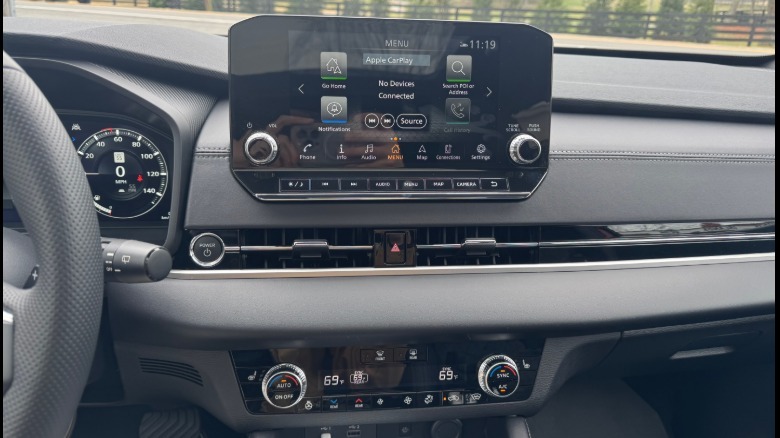 A close-up of the center stack in the Rogue PHEV showing the center infotainment screen with buttons and knobs as well as the HVAC controls with buttons and knobs.