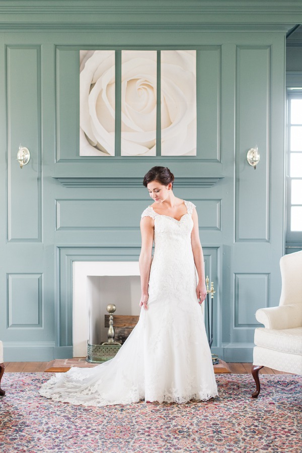 Bride in cap-sleeve V-neck lace fit-and-flare wedding gown standing indoors at Dulany's Overlook wedding venue in Maryland