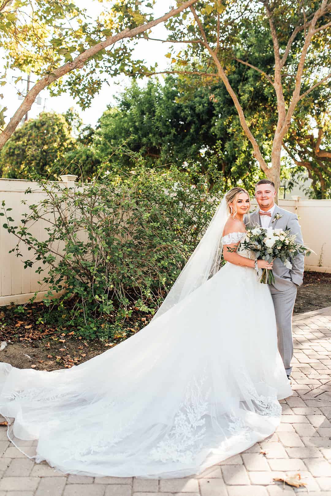 Bride and groom at Strathearn Historical Park, bride in off-shoulder embroidered tulle and lace ballgown with long cathedral train in Simi Valley California