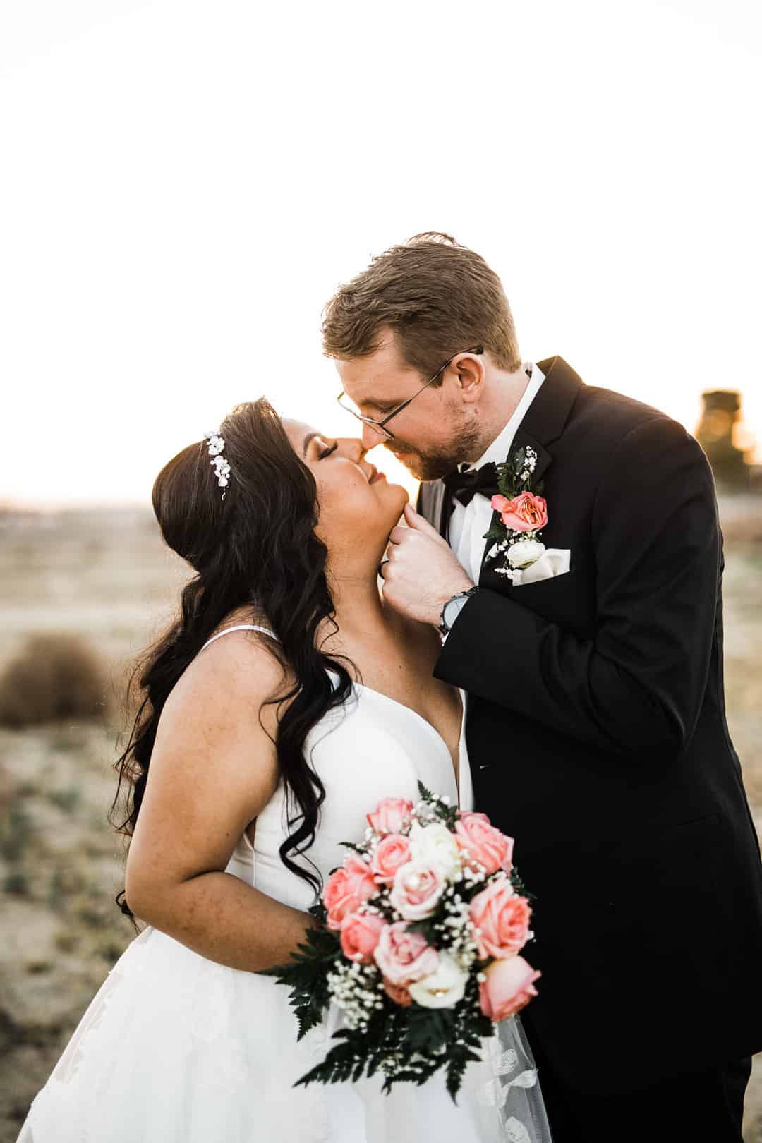 Groom cupping the bride's chin and tilting her face up, noses nearly touching