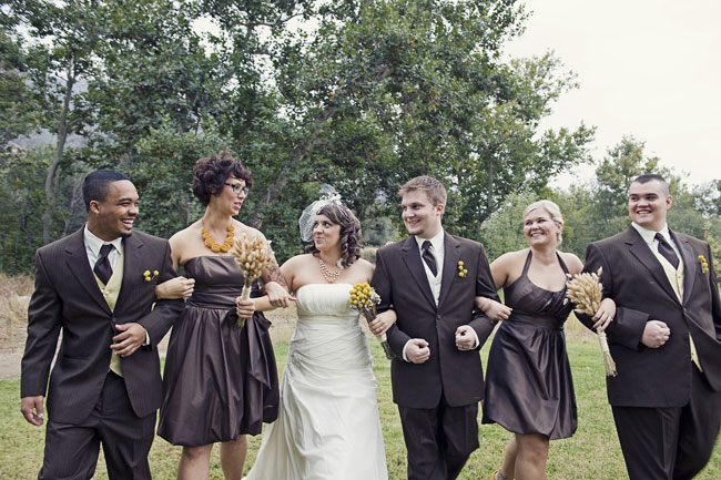 Bridesmaids in short chocolate brown dresses holding yellow billy ball bouquets