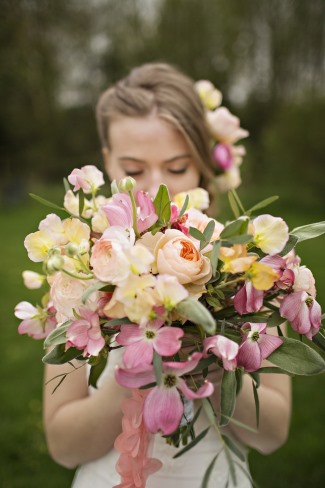 Soft bouquet of peach and butter-yellow ranunculus with sweet peas and tulips