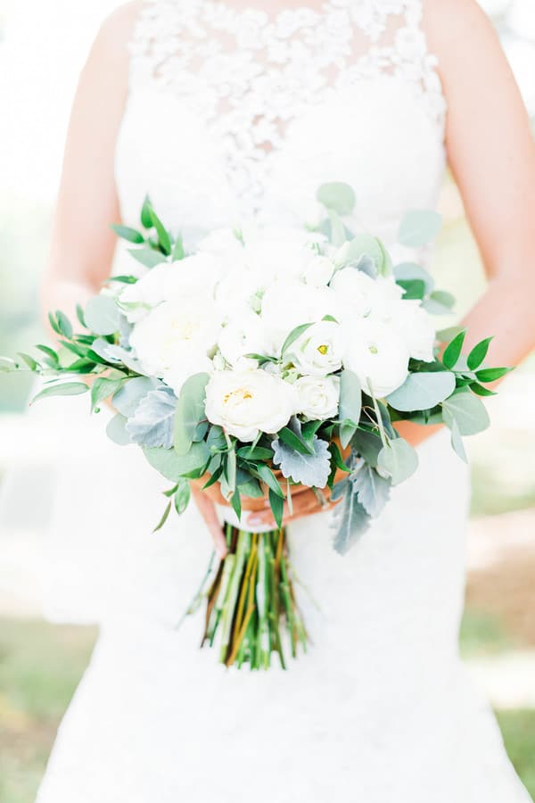 All-white bouquet of ranunculus and garden roses with dusty miller and eucalyptus