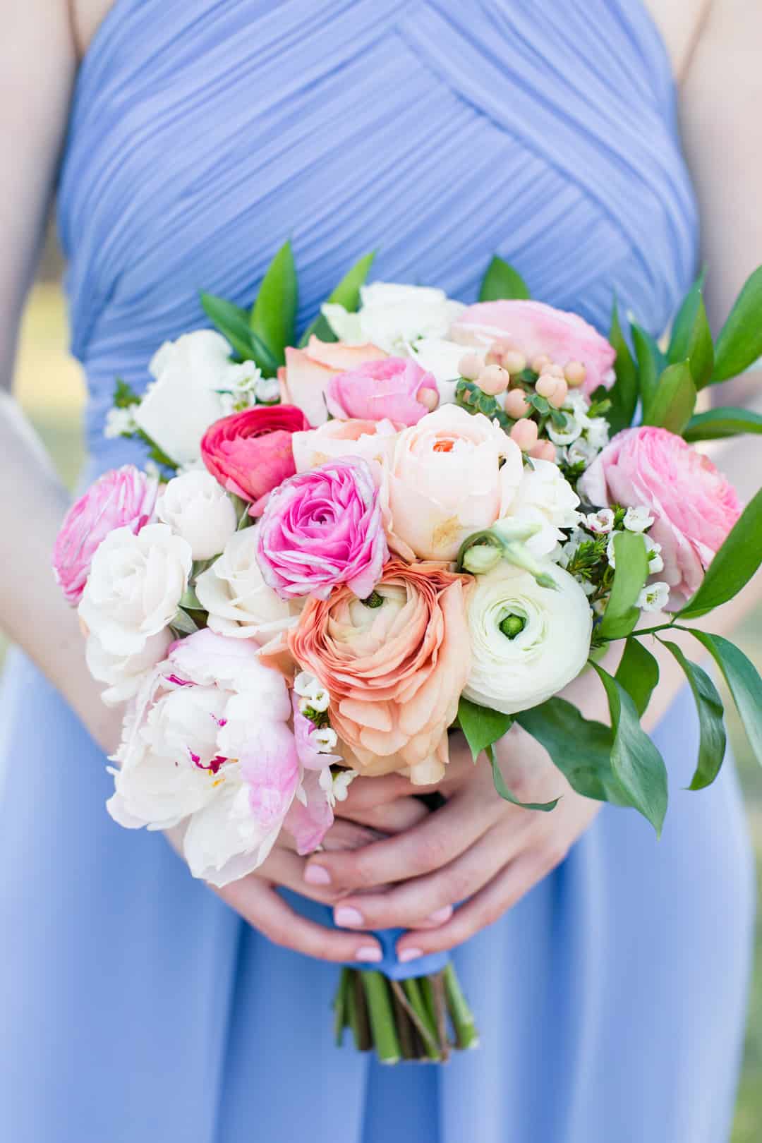 Bouquet full of peach, pink and white ranunculus with blush peonies and berries