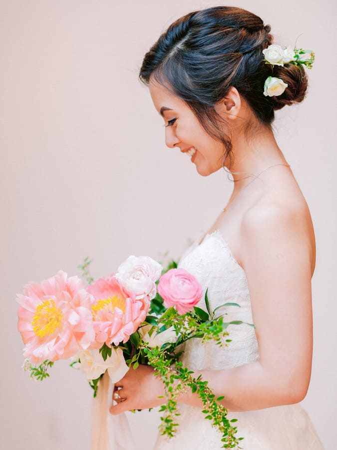 Bouquet of blush and pink ranunculus with pink peonies and greenery