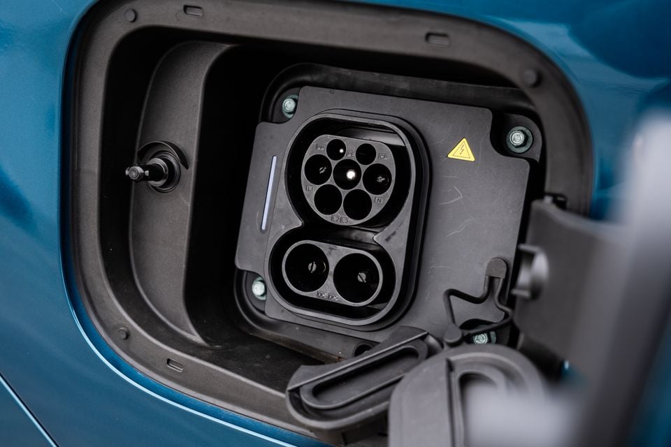 Close-up of a CCS Type 2 combined charging port on a blue 2026 Chery Tiggo 7 Super Hybrid, with the charge flap open
