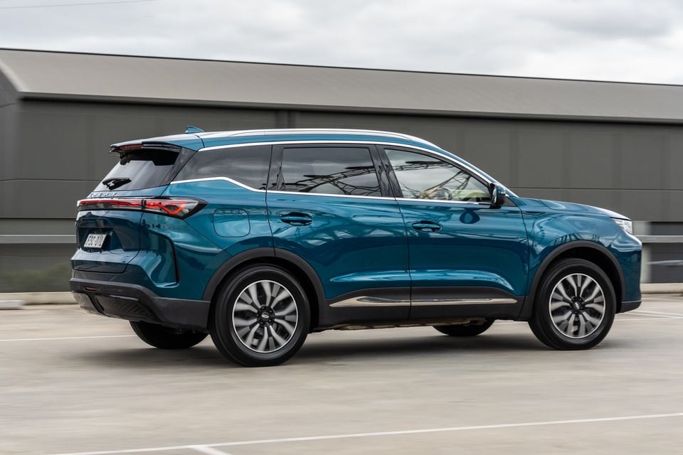 A teal 2026 Chery Tiggo 7 Super Hybrid SUV seen from the rear three-quarter angle while driving