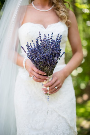 Bride holding an upright bundle of dried purple lavender