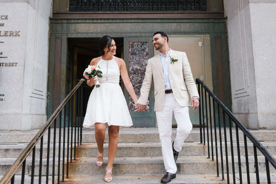 Bride and groom on the steps of the Manhattan Marriage Bureau