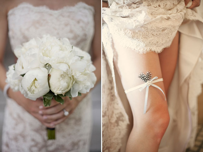All-white peony wedding bouquet tied with satin ribbon against a lace gown