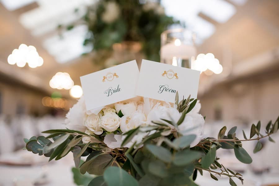 White roses and eucalyptus greenery with candlelight behind