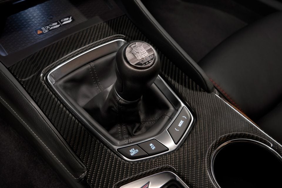 Manual gear shifter with an anniversary crest on the knob, set in a carbon-fibre centre console in the 2025 Cadillac CT5-V Blackwing