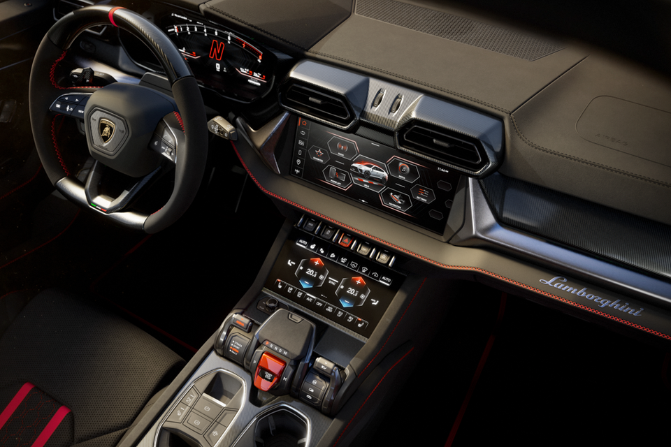 Interior of the 2026 Lamborghini Urus Performante showing the steering wheel, central touchscreen infotainment system, climate control panel, and centre console with gear selector