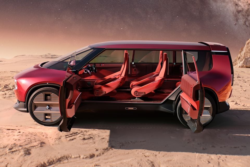 Red Renault concept people mover seen side-on with front and rear doors open, revealing red seats, parked on a desert landscape under a starry sky