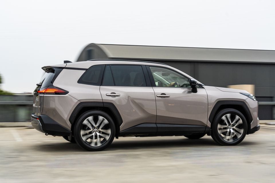 A beige 2026 Toyota RAV4 Cruiser SUV photographed from the side while driving on a rooftop car park