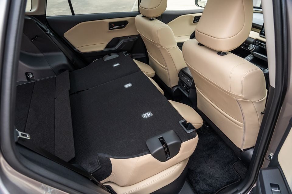 The rear seats of a 2026 Toyota RAV4 Cruiser are folded flat to show the extended cargo area with beige leather upholstery.