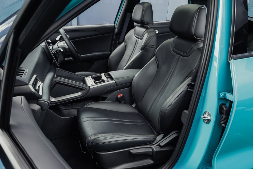 The black leather front seats and centre console of a 2027 BYD Atto 2 DM-i, seen through the open driver's door