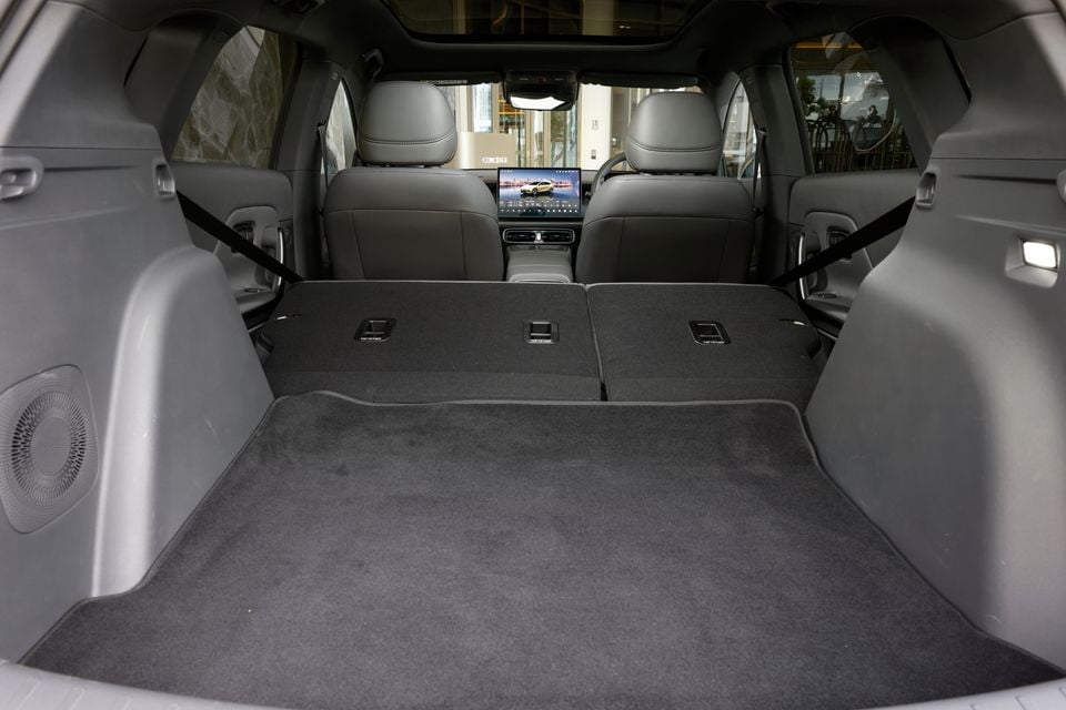 Boot of the 2027 Leapmotor B05 with rear seats folded flat, showing the carpeted load floor, front seats and central touchscreen beyond