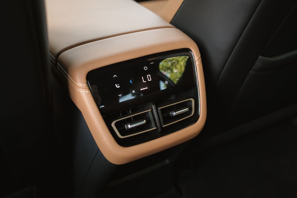 Close-up of the rear climate control panel and air vents on the centre console of a 2027 Mazda 6e Atenza, with tan leather trim.