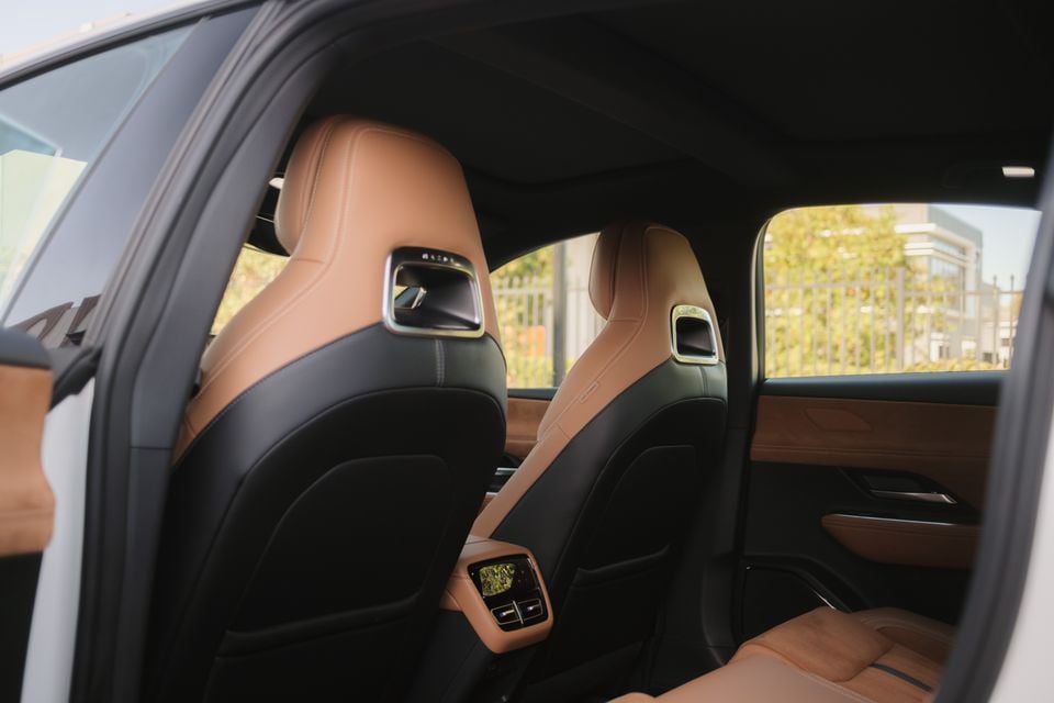 The back seats of a 2027 Mazda 6e Atenza sedan, shown in tan and black leather with rear air vents.