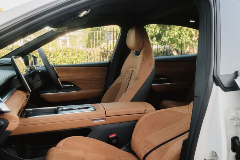 The tan leather front seats and centre console of a 2027 Mazda 6e Atenza, viewed through the open driver's door.