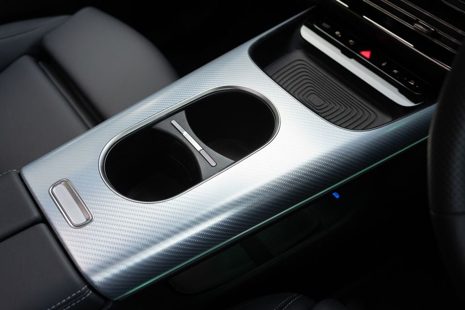 Centre console of the 2027 Mercedes-Benz GLB 350 4Matic electric with carbon-look trim, twin cupholders and a wireless phone charging pad