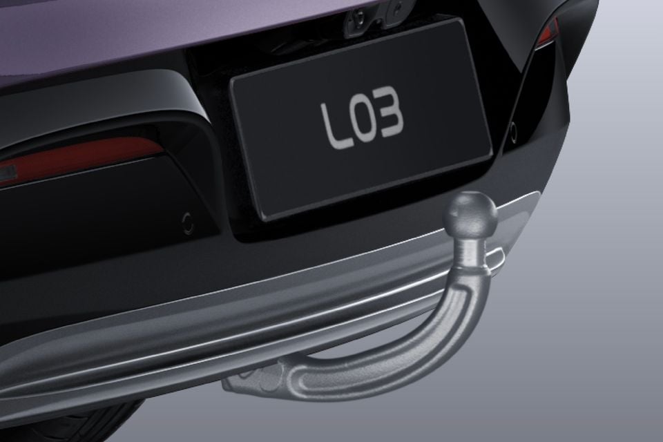 Close-up of a tow bar fitted beneath the rear bumper of a purple Xpeng L03, with the number plate reading L03.